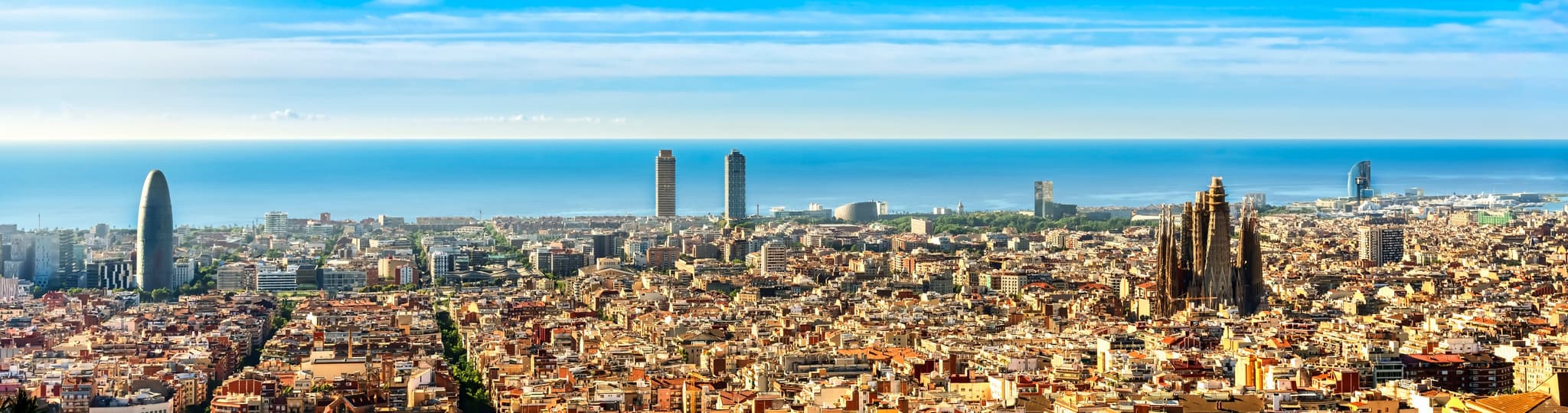 Vista aérea de Barcelona hacia el Mediterráneo, con las torres de la Vila Olímpica junto al mar.
